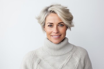 Portrait of smiling woman in sweater looking at camera over white background