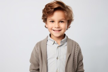 smiling little boy in casual clothes looking at camera isolated on grey