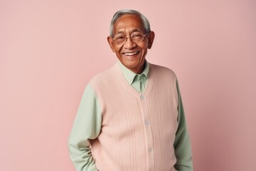 Fototapeta premium Portrait of a happy senior asian man smiling against pink background