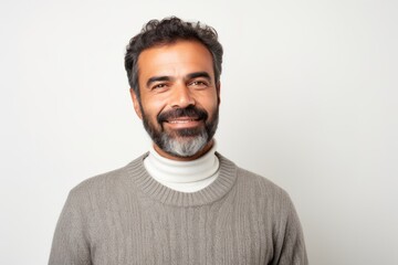 Handsome Indian man in turtleneck sweater smiling at the camera