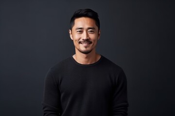 Obraz premium Portrait of a handsome young asian man on black background.