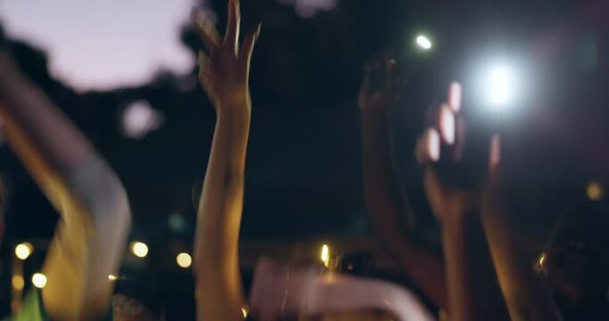 Dancing, party and people celebrate at a festival or concert together at a outdoor social event with music and drinks. Flashlight, night and young friends at a birthday gathering or reunion vacation