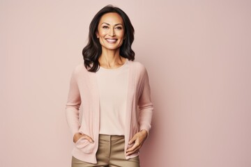 Obraz premium Smiling african american woman in pink sweater and beige pants