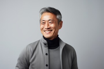 asian senior man smiling and looking at camera isolated on grey background