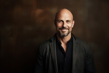 Portrait of a handsome bald man in a black jacket. Studio shot.