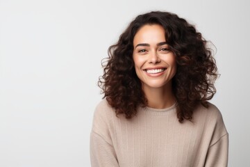 Portrait of a smiling young woman with curly hair looking at camera isolated over white background