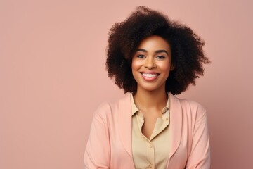 Obraz na płótnie Canvas smiling african american woman in pink suit on pink background