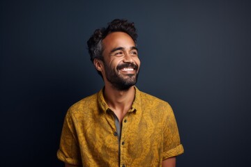 Fototapeta premium Portrait of a happy young indian man smiling at the camera