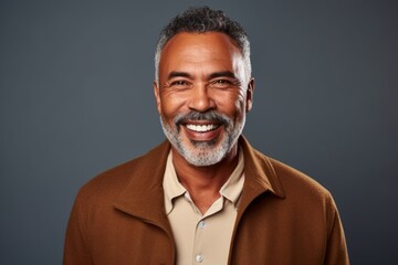 Fototapeta premium Portrait of a smiling mature man looking at camera isolated over grey background
