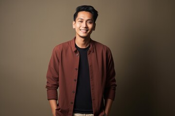 Obraz premium Portrait of a young asian man smiling at camera on grey background