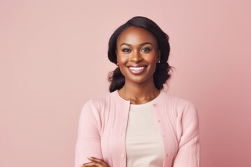 Obraz premium Portrait of beautiful african american woman smiling on pink background