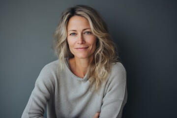 Portrait of a middle-aged woman in a gray sweater on a gray background