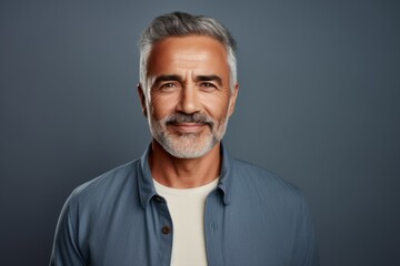 Fototapeta premium Portrait of mature man with grey hair and beard looking at camera