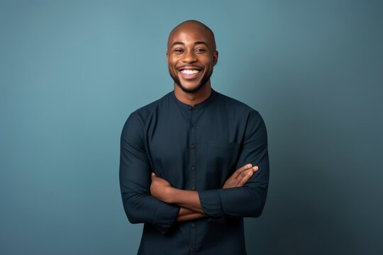 Portrait of happy african american man with crossed arms on blue background