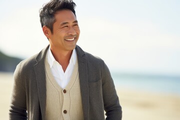Portrait of a handsome young man smiling at the beach on a sunny day