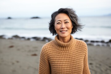 Portrait of a smiling asian woman in sweater on the beach
