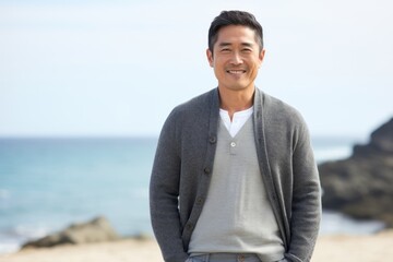 Portrait of a smiling asian man standing on the beach at the day time