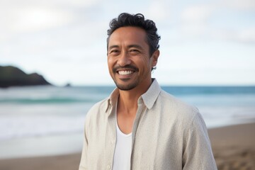 Portrait of smiling man standing on beach in front of ocean at daytime