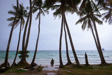 People enjoying the white sand beach on a cloudy day. Boracay, Philippines