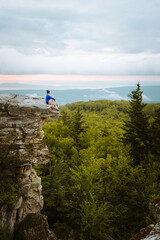 Woman sitting on a rock's edge at Bear Rocks Preserve in the Dolly Sods Wilderness, West Virginia