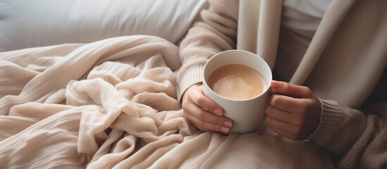 Young woman hand holding white cup of coffee on the bed in the morning.Generative ai - obrazy, fototapety, plakaty