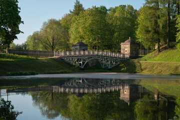 Fototapeta na wymiar View of the White Lake in Gatchina Park and the stone bridge at the Konetable Square on a sunny summer day, Gatchina, Leningrad region, Russia
