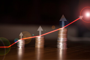 Stacking coins on the wooden table and growth graph line chart target to save money or investment of business concept income by finance  marketing
