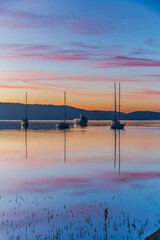 Beautiful sunrise waterscape with high cloud, reflections and boats
