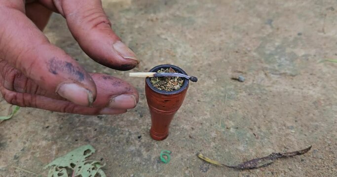 Indian Village man taking or smoking Chilum(Marijuana, Cannabis.