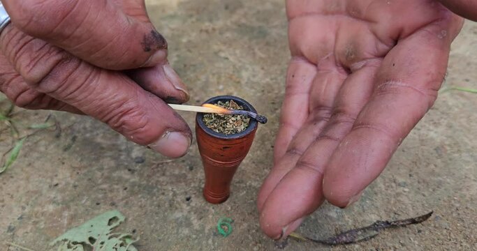 Indian Village man taking or smoking Chilum(Marijuana, Cannabis.
