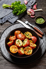 Herbs Garlic Potatoes in black bowl, top view