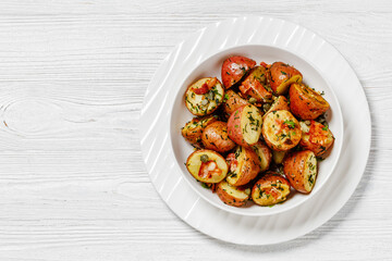 Herbs Garlic Potatoes in white bowl, top view