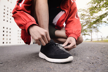young man tying shoelaces, sport concept