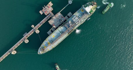 crude oil floating station in sea, bridge pipeline load unloading crude oil from oil ship transport, industry business transportation by container ship open sea, aerial drone point of view 4k video