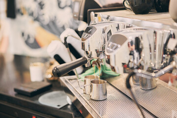 A small coffee business. Makes espresso, Americano with a takeaway. A professional barista prepares coffee in a carob coffee machine. Favorite job in the restaurant industry.