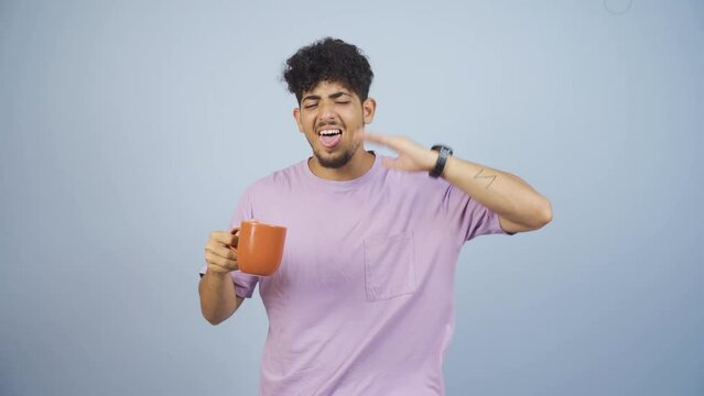 The man's mouth is burning from the hot drink.