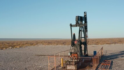 Arc shot made with a drone of pumpjack working at an oil well in Argentina. Petroleum industry, fossil fuel extraction concepts