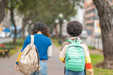 Naklejka premium Female students with their backs turned walking with their backpacks