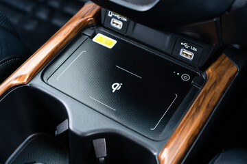 Wireless mobile charger in the modern car. Portable wireless car charger for smartphone.