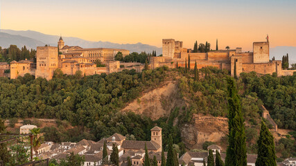 Fototapeta na wymiar The Alhambra fortress in Granada, Spain during sunset. Fortress is bathed in golden-reddish light.