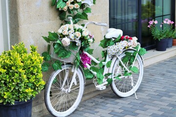 Fototapeta na wymiar retro bicycle decorated with flowers at the entrance to the flower shop