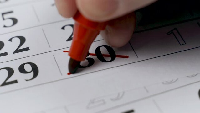 The thirtieth number on the calendar is boldly crossed out with a red marker as a completed important event. Close-up.