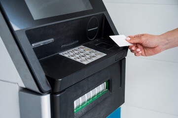 Close-up of woman's hands using ATM with contactless nfs access. 