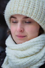 Woman is a young portrait. In a white hat on the street. Winter, Conifers