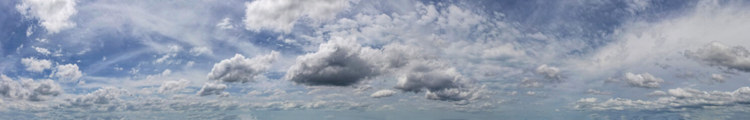 Fototapeta premium Panoramic view revealed a heavenly display of beautiful white clouds suspended against the backdrop of a serene blue sky, painting a scene of tranquility.