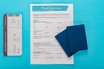 Travel insurance policy with boarding pass and passports isolated on blue background