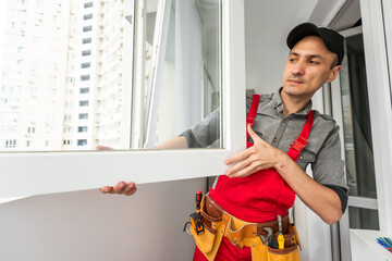 low angle view of installer standing near windows and holding measuring tape