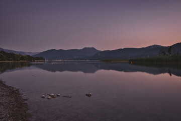 Lake with the reflection of mountains and lights on the water surface in Gmund am Tegernsee, Germany