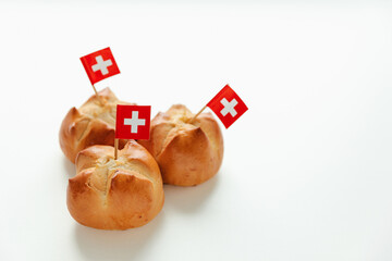 Traditional Swiss bread bun with a cut in the shape of the Swiss flag called in German Augustweggli being baked on the eve of the Swiss National Day on August 1st