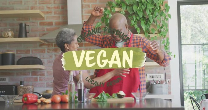 Animation of vegan food text over african american couple preparing veggies in kitchen